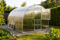 Serre de jardin en polycarbonate avec structure en aluminium dans un potager